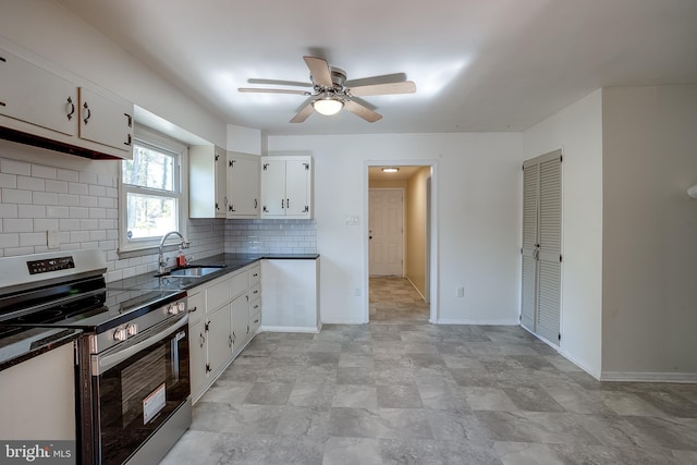 kitchen featuring stainless steel electric range, ceiling fan, dark countertops, a sink, and backsplash