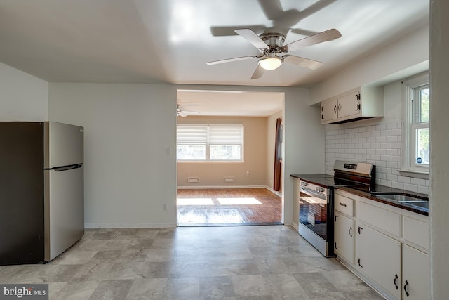kitchen featuring a healthy amount of sunlight, dark countertops, a ceiling fan, and stainless steel appliances