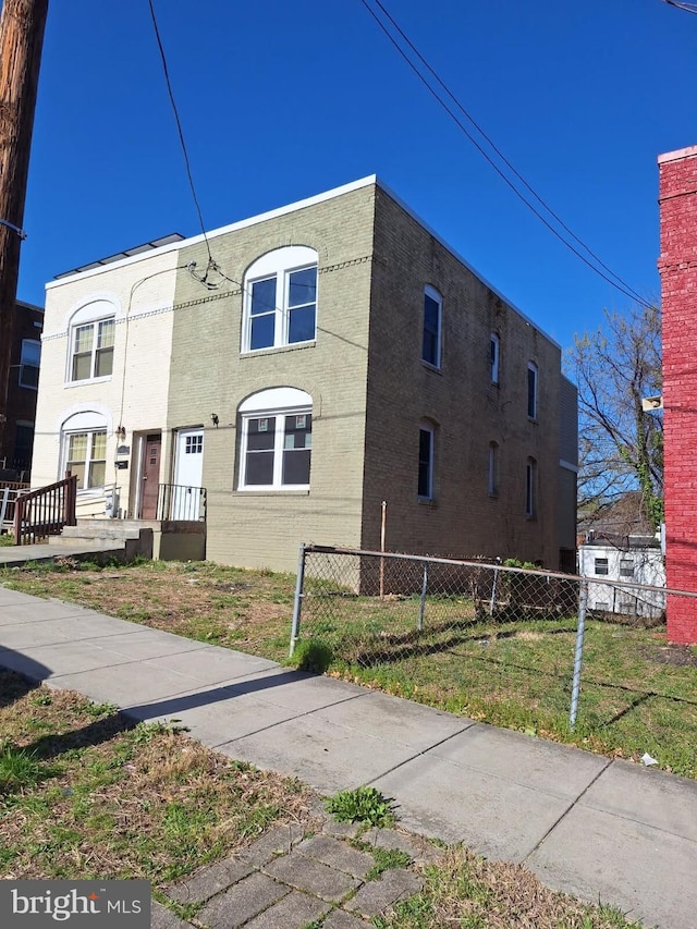 view of front facade featuring fence private yard and a front yard