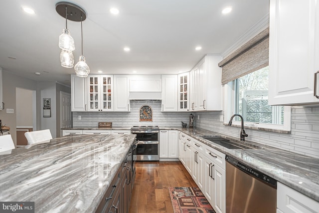 kitchen with a sink, appliances with stainless steel finishes, decorative backsplash, and light stone countertops