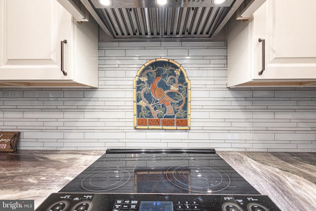 kitchen featuring light stone counters, white cabinetry, backsplash, and custom exhaust hood