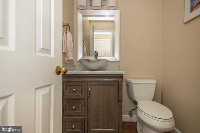 bathroom with vanity, baseboards, and toilet