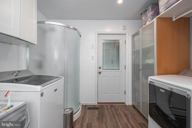 clothes washing area featuring visible vents, dark wood-style floors, cabinet space, and washer and clothes dryer