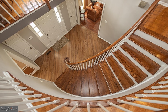 stairway featuring visible vents and wood finished floors