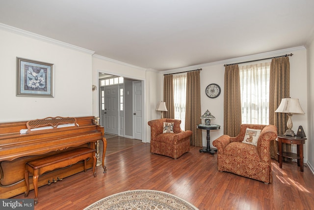 living area featuring plenty of natural light, ornamental molding, and wood finished floors