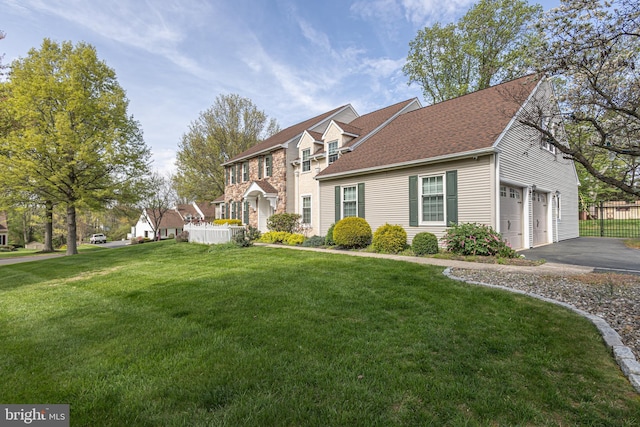 view of front of property featuring fence, aphalt driveway, a shingled roof, and a front lawn