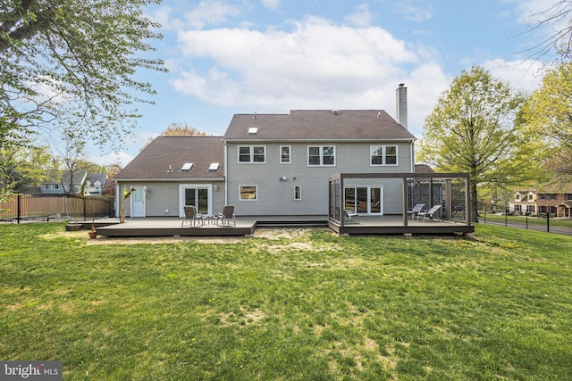 back of property with a fenced backyard, a yard, a chimney, and a deck
