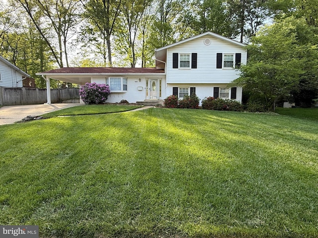 split level home with fence, a carport, driveway, and a front lawn