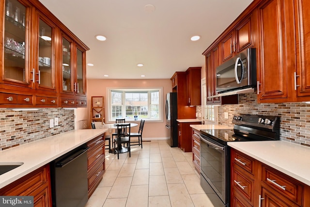 kitchen featuring recessed lighting, light countertops, backsplash, and stainless steel appliances
