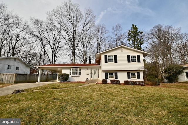 split level home with a front lawn, fence, driveway, and an attached carport