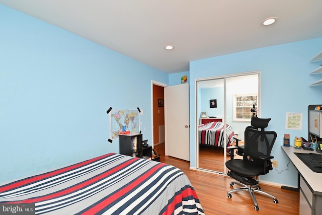 bedroom with a closet, recessed lighting, and wood finished floors