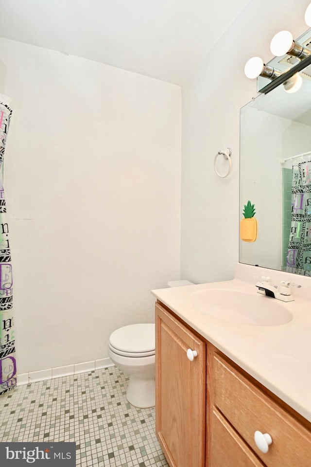 bathroom featuring vanity, baseboards, curtained shower, and toilet