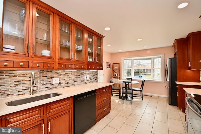 kitchen featuring a sink, light countertops, tasteful backsplash, and stainless steel appliances