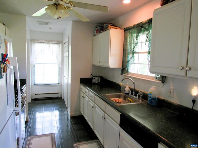 kitchen featuring baseboard heating, dark countertops, plenty of natural light, and a sink