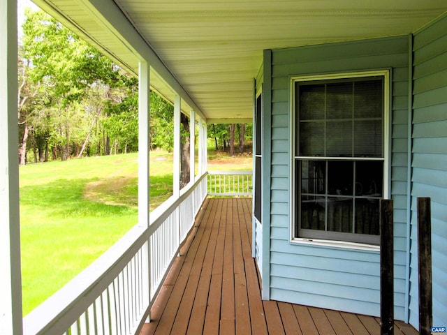 wooden deck with a yard and covered porch