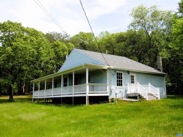 back of property featuring a lawn, a shingled roof, and a chimney