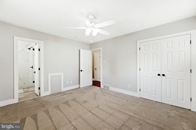 unfurnished bedroom featuring ensuite bath, carpet, baseboards, visible vents, and a closet