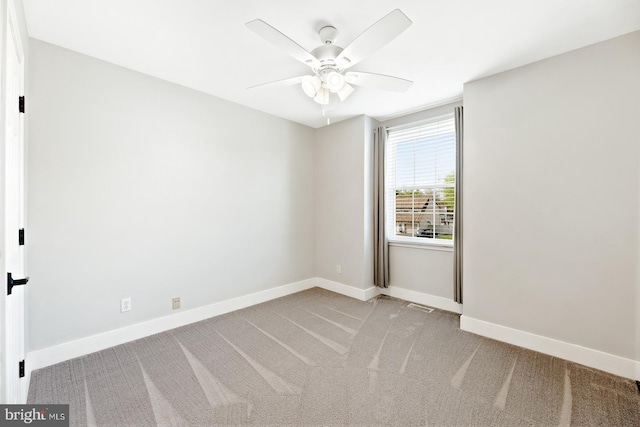 spare room with baseboards, light carpet, a ceiling fan, and visible vents