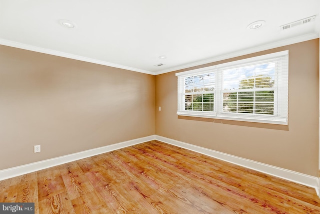 empty room featuring visible vents, ornamental molding, baseboards, recessed lighting, and light wood finished floors