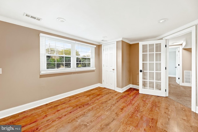 unfurnished room with baseboards, ornamental molding, french doors, and visible vents
