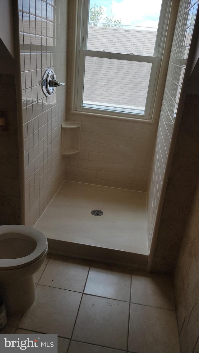 bathroom featuring tile patterned floors, a stall shower, and toilet