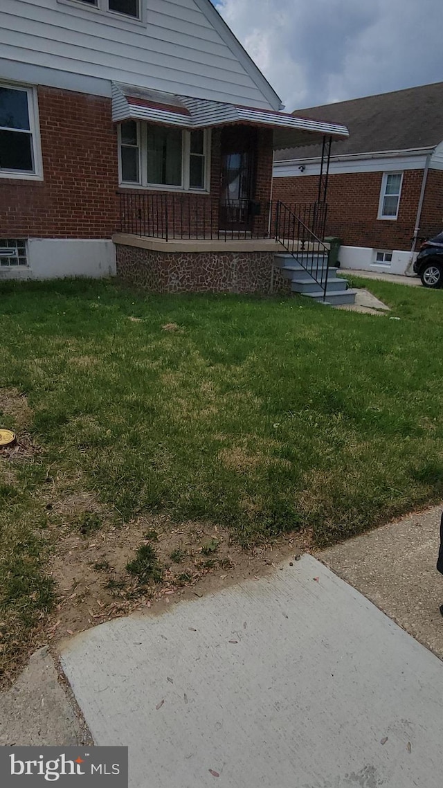 exterior space featuring a lawn and brick siding