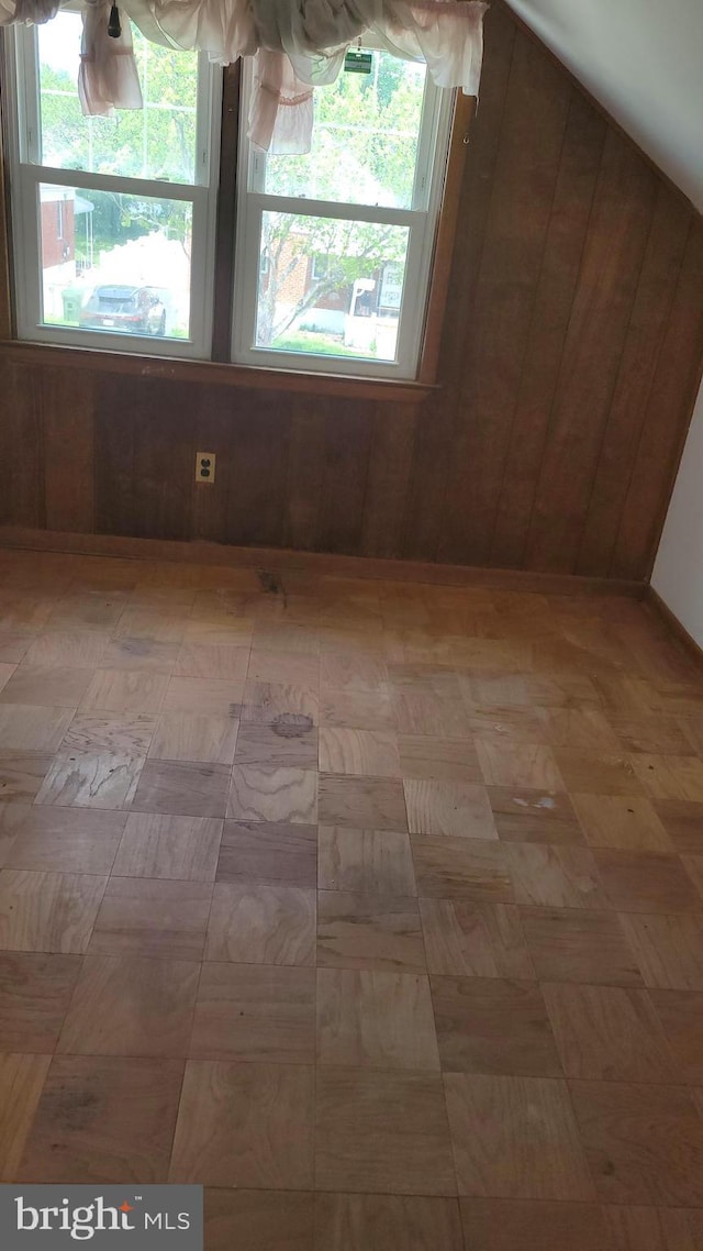 empty room with a healthy amount of sunlight and wood walls