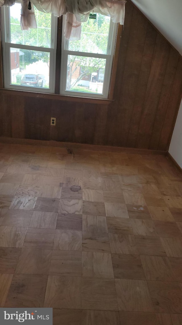 empty room with wood walls and plenty of natural light