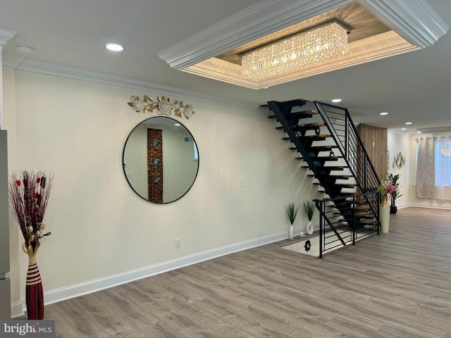 interior space with an inviting chandelier, ornamental molding, wood finished floors, baseboards, and stairway