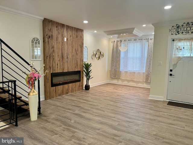 foyer featuring crown molding, stairs, wood finished floors, baseboards, and recessed lighting