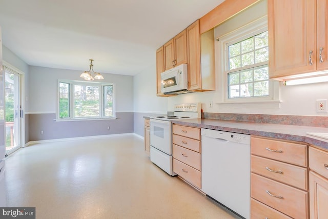 kitchen featuring a healthy amount of sunlight, light brown cabinets, an inviting chandelier, and white appliances