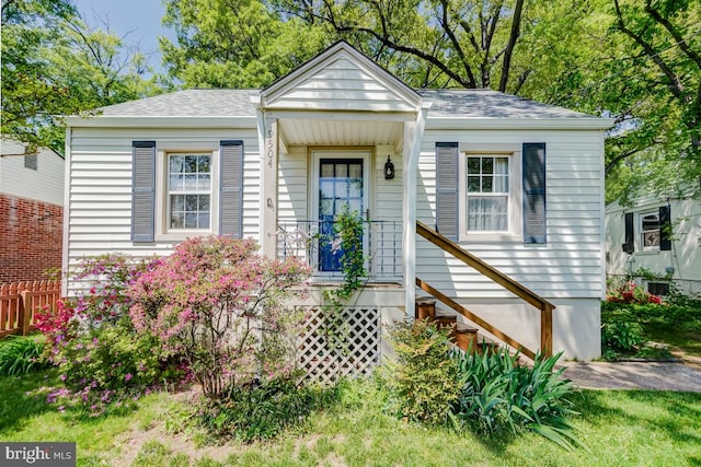 bungalow-style house with roof with shingles and fence