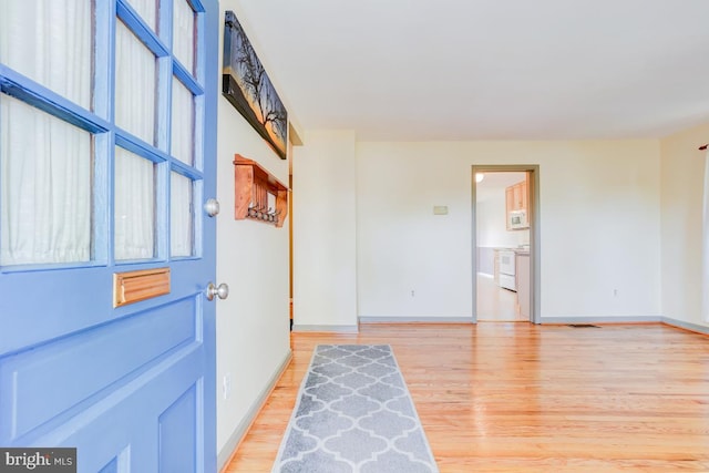 foyer featuring baseboards, light wood-style flooring, and visible vents