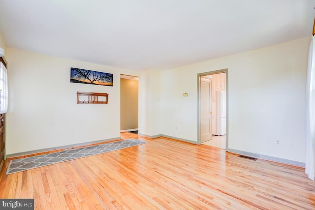empty room with baseboards, visible vents, and light wood-style flooring
