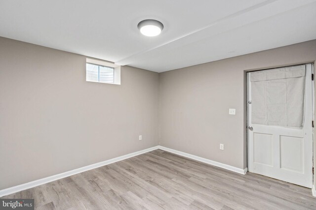 below grade area with baseboards and light wood-style flooring