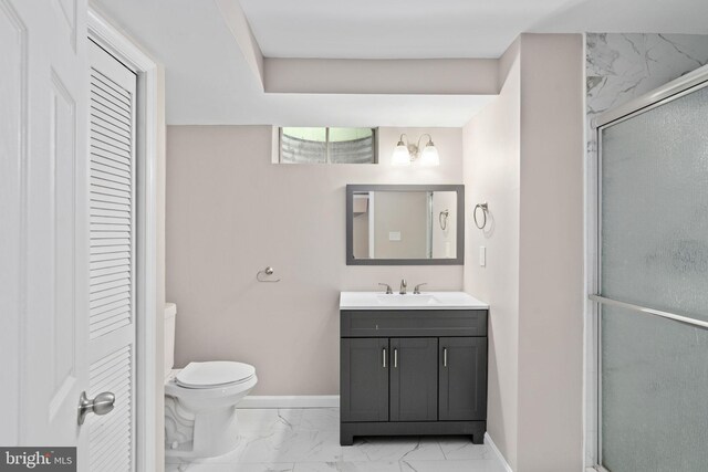 bathroom featuring vanity, toilet, marble finish floor, baseboards, and a shower stall