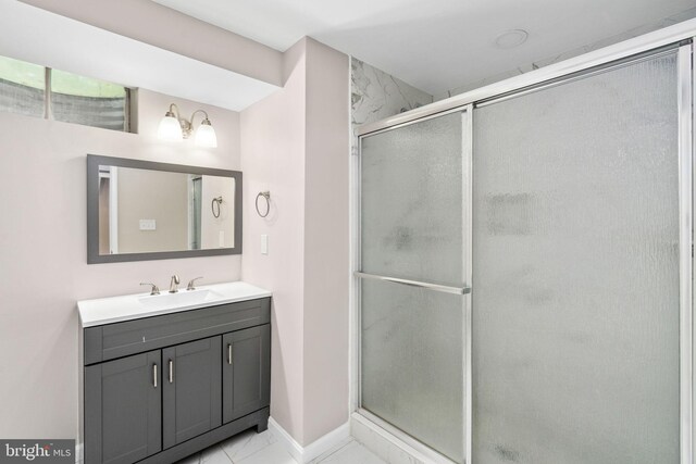 bathroom featuring vanity, baseboards, and a stall shower