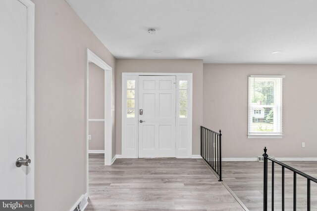 entrance foyer with light wood-style floors, baseboards, and plenty of natural light