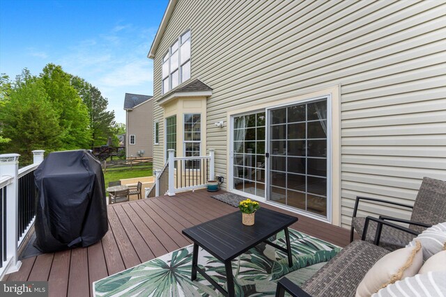 wooden deck with outdoor dining space and a grill