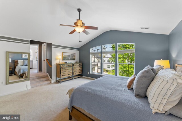 carpeted bedroom with visible vents, a ceiling fan, baseboards, and vaulted ceiling