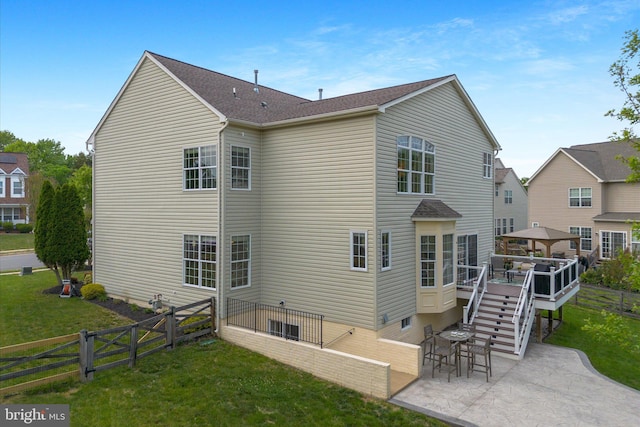 rear view of property with fence, stairs, a wooden deck, a patio, and a yard