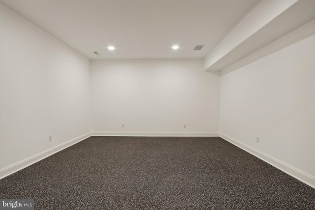 empty room featuring baseboards, recessed lighting, dark carpet, and visible vents