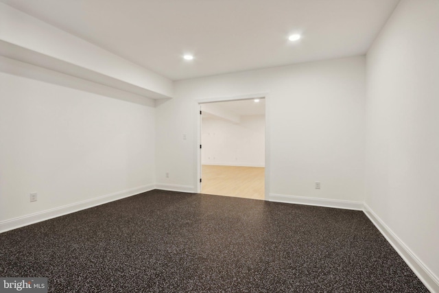 empty room featuring baseboards, recessed lighting, and speckled floor