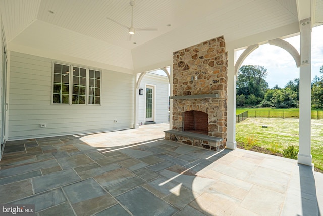view of patio / terrace with fence and an outdoor stone fireplace