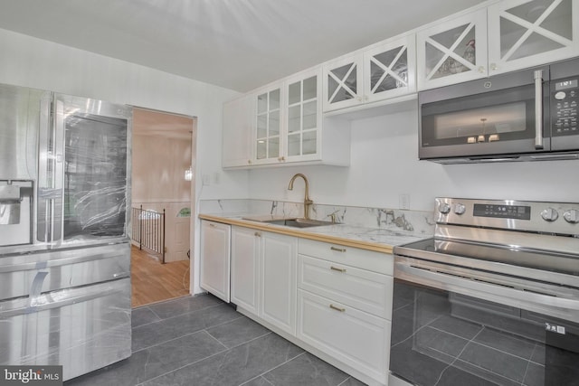 kitchen featuring a sink, light countertops, stainless steel appliances, and white cabinetry
