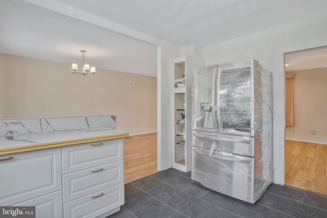 interior space with an inviting chandelier, baseboards, tile patterned flooring, and a shower