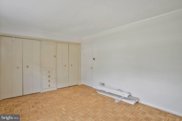 unfurnished bedroom featuring visible vents and ornamental molding