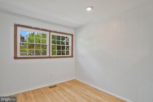 unfurnished room with visible vents, baseboards, and wood finished floors