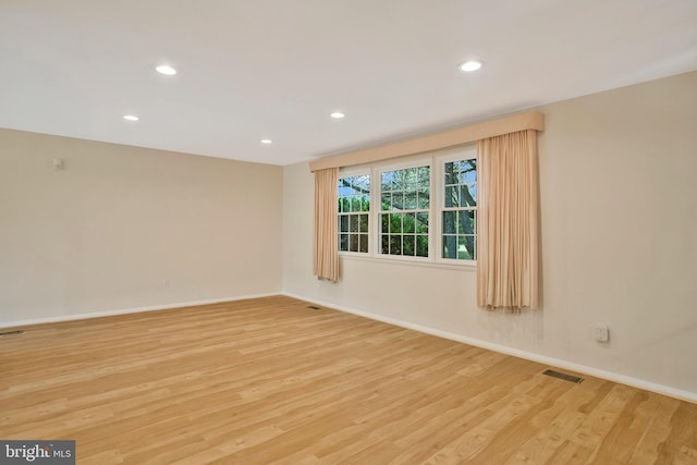 empty room with visible vents, recessed lighting, light wood-style flooring, and baseboards