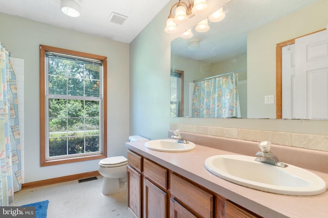 13478 Spruce, King George, VA 22485 - full bathroom featuring double vanity, toilet, tile patterned floors, baseboards, and a shower with shower curtain
